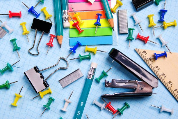 School and office stationery on a white sheet. The concept of education, office work, business, entrepreneurship. Workplace freelancer. Close up.
